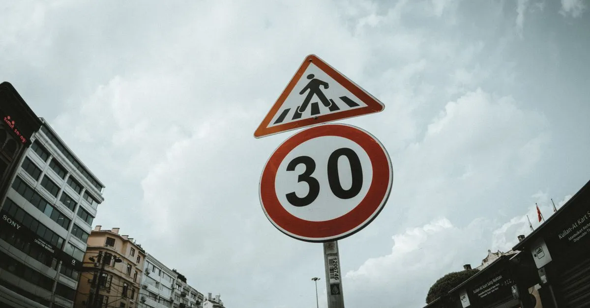 Low-angle view of pedestrian and speed-limit road signs against a cloudy sky, standing in for the rel attributes that label a link.