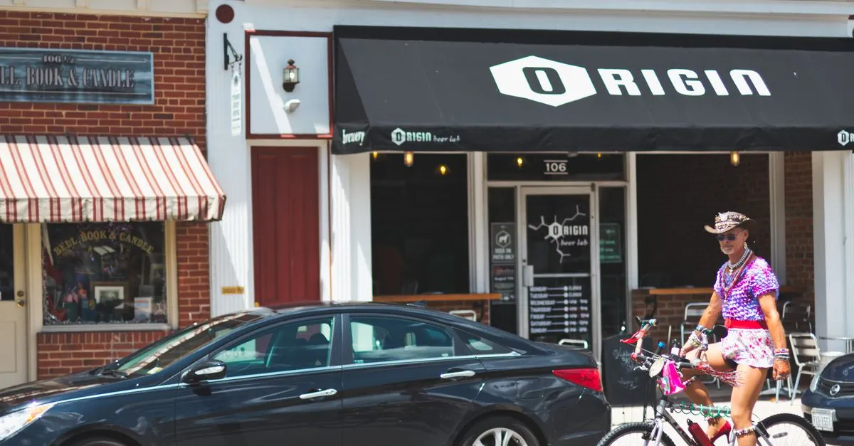 A row of independent brick storefronts along a walkable business district, a neighborhood bar and a bookshop side by side, the kind of local shops Omaha neighborhoods are full of.