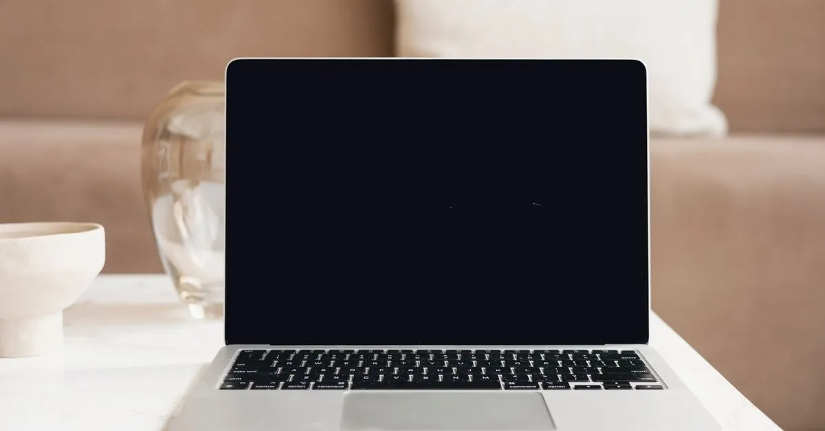 A laptop with a blank screen on a white table, the clean canvas behind a Tampa website build.