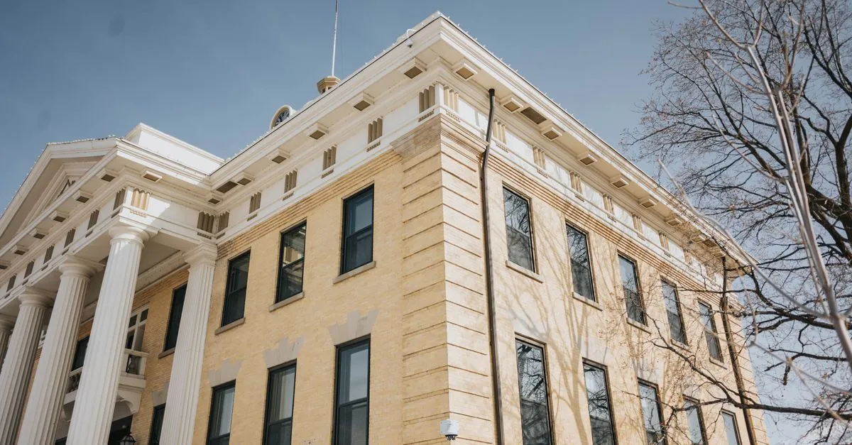 A county courthouse exterior with tall columns, where criminal charges are arraigned and tried.