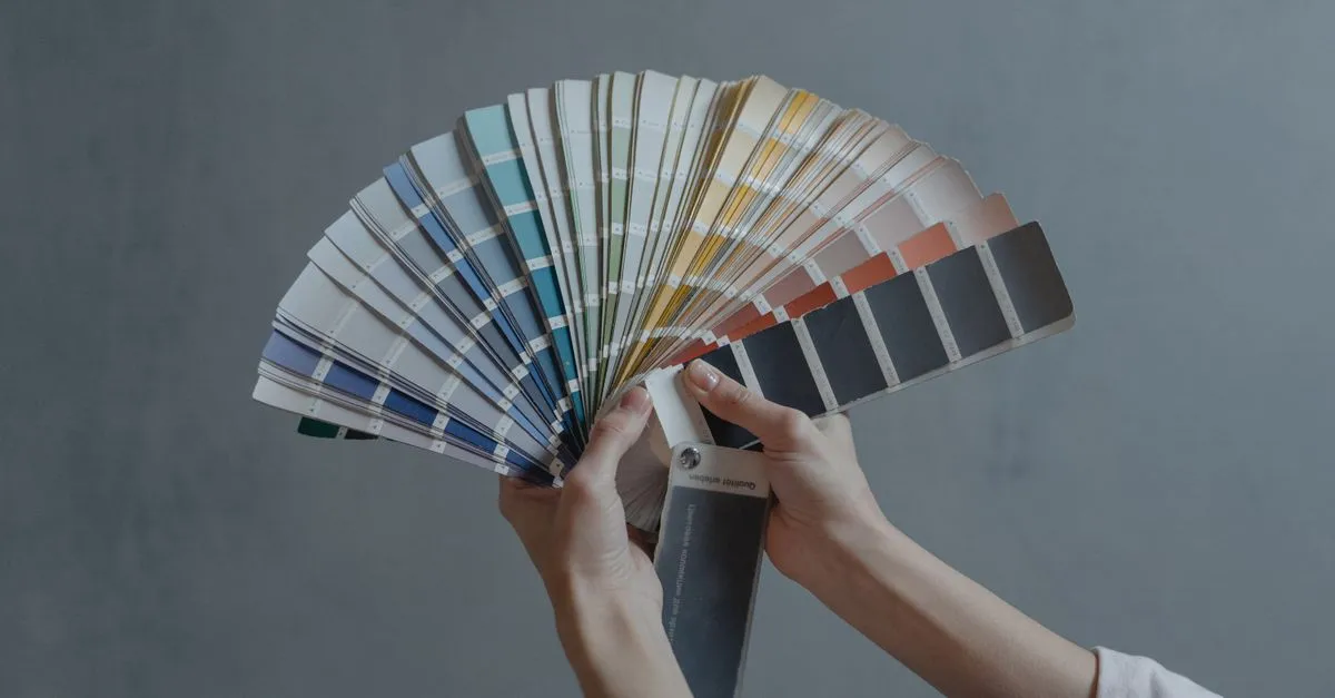A hand holding a fan of color swatches, the design choices behind a Memphis website build.