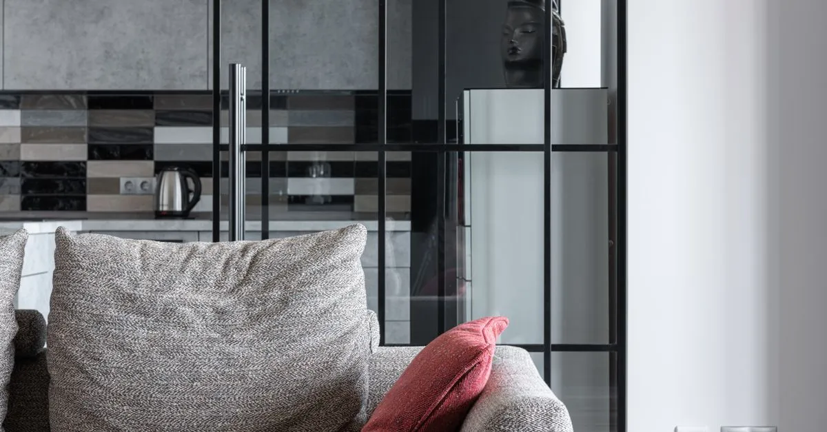A stylish textured sofa with a red throw pillow in a living room, the kind of piece a furniture store SEO page helps buyers discover.