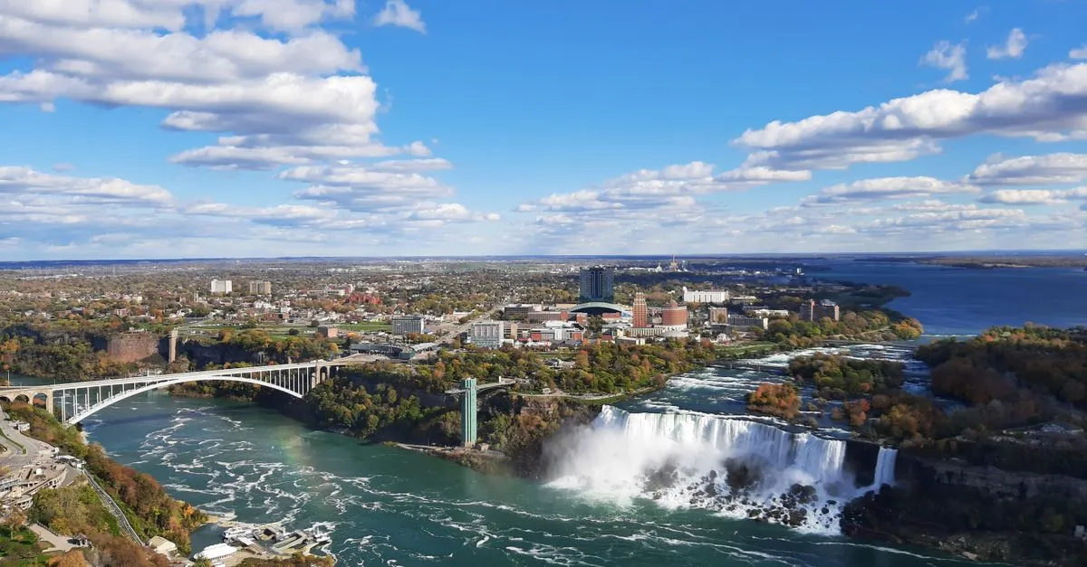 An aerial view of Niagara Falls, the Rainbow Bridge, and the surrounding city in the Buffalo Niagara region of Western New York.