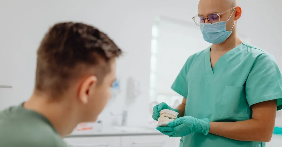 A dentist talking through a treatment with a patient in the office, building the trust that turns a near me search into a booked appointment.