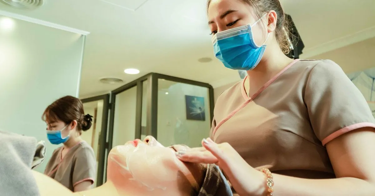 An esthetician applying a skincare treatment to a client during a facial at a med spa.