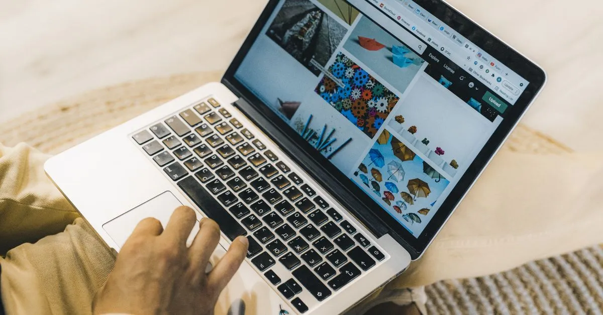 A designer reviewing a web design portfolio on a laptop, the way a prospect sizes up an agency before hiring.