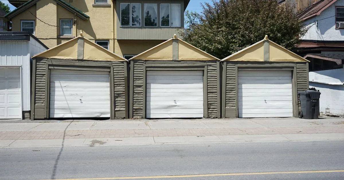 A row of residential garages on a neighborhood street, the service-area radius a garage door company covers.