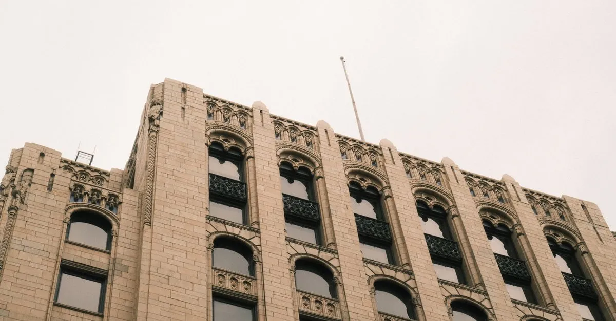 The upper stories of a historic stone office building with ornate arched windows in downtown Grand Rapids, Michigan.