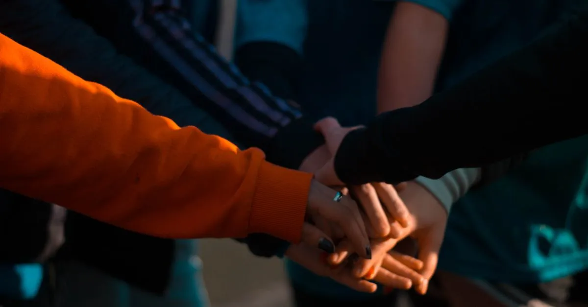 Hands stacked together in a support group at a recovery center, the kind of local center that wins near me searches.