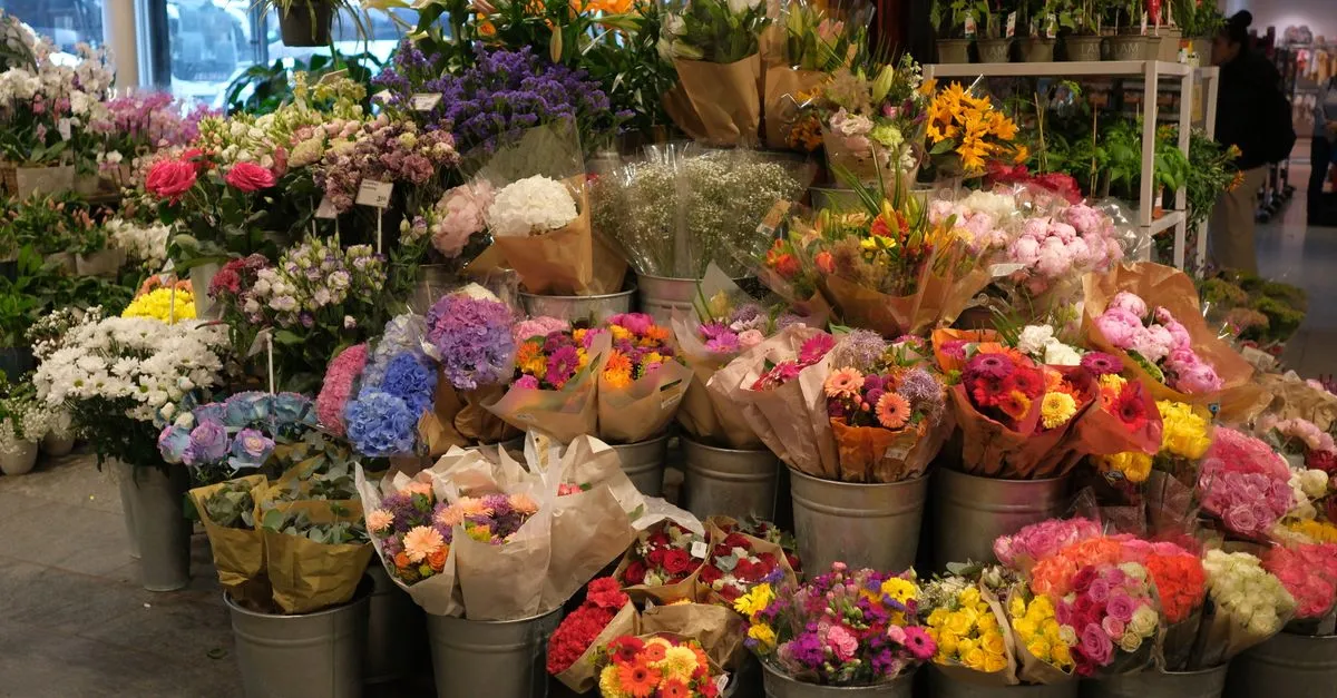 Colorful buckets of fresh cut flowers and bouquets on display in a local florist shop.