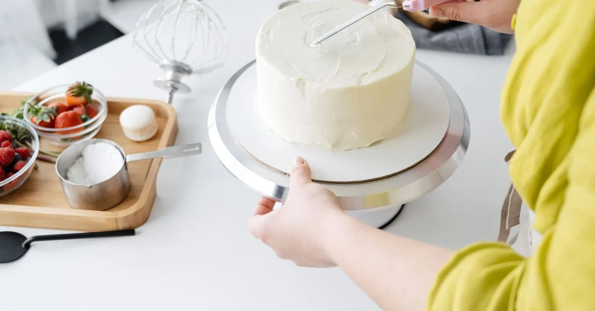 A baker decorating a custom cake by hand, the kind of special order local SEO helps a bakery win.