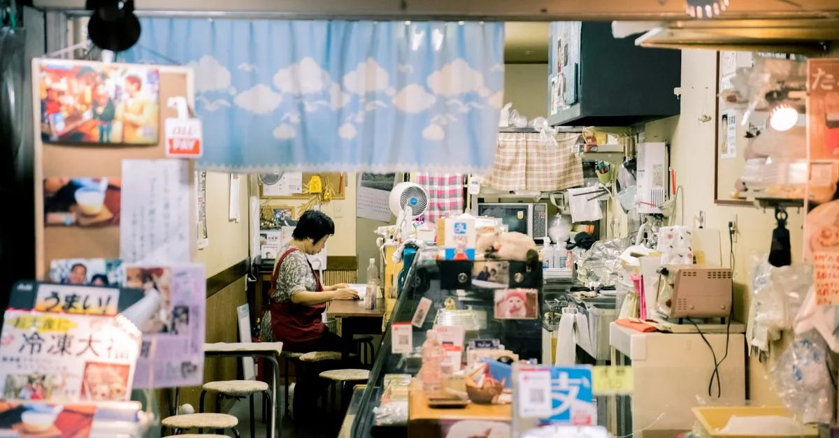 A shop owner working at the counter inside a warm, well-stocked retail store that local shoppers discover through search.