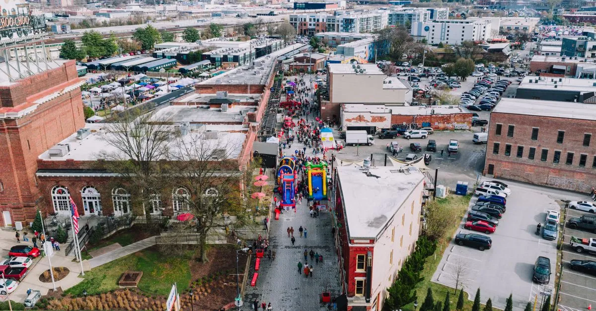 Aerial view of a spring street festival in the Southside district of Chattanooga, Tennessee, with crowds along a brick street near the historic Chattanooga Choo Choo.