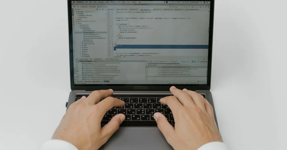 An overhead close-up of hands typing on a laptop keyboard with a code editor open on the screen.