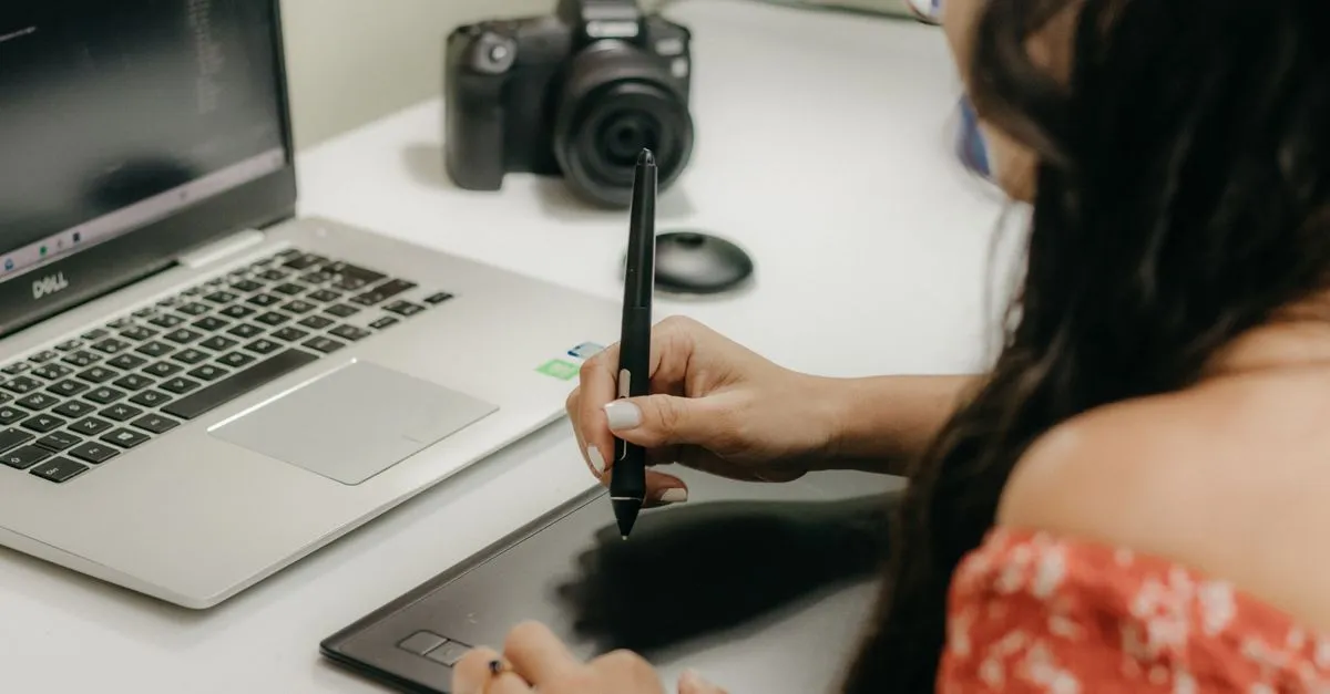 A designer holding a pen over a tablet, sketching the layout for a fast Jacksonville website.