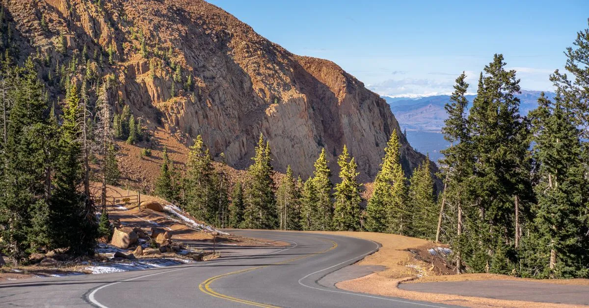 A winding mountain road climbing through pines toward the peaks above Colorado Springs, the kind of local market local SEO is built for.