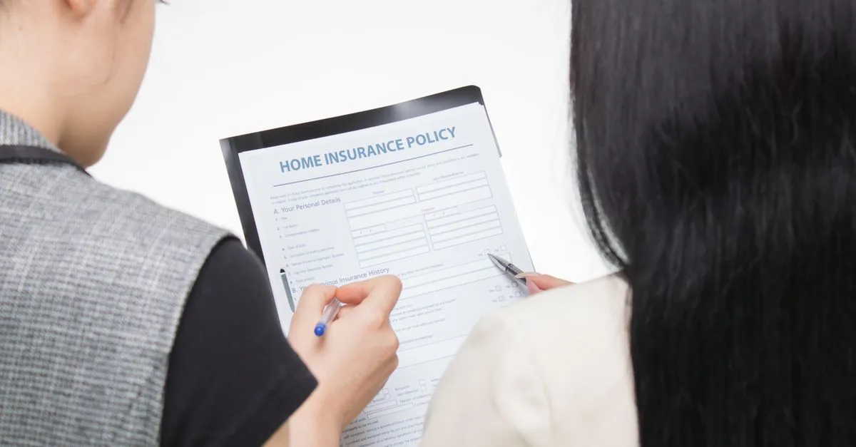 A person reviewing a home insurance policy document before choosing an agency they found through search.