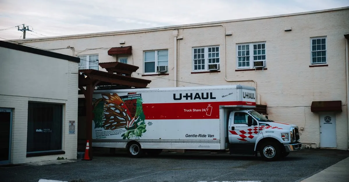 A moving company box truck parked outside a warehouse, loaded and ready for the next job.