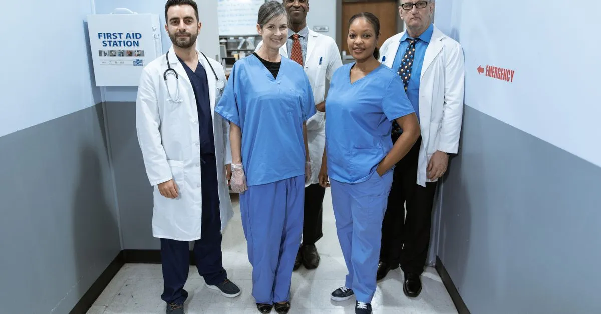 A team of doctors and nurses walking together through a hospital hallway.