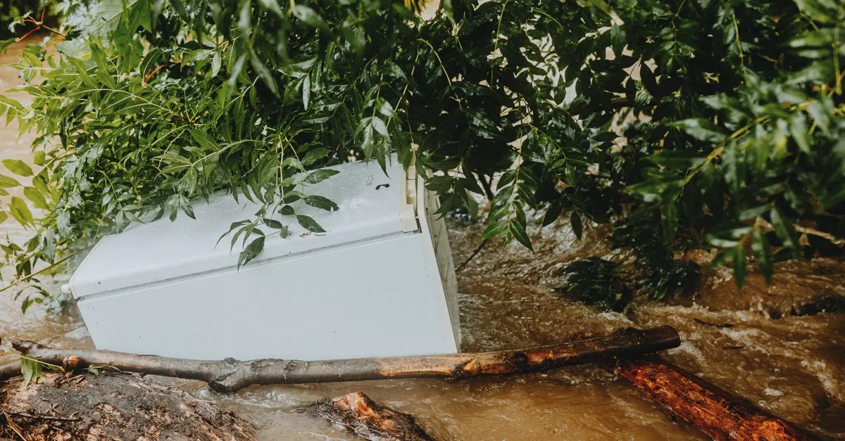 A washing machine swept away by floodwaters and debris, the kind of storm and water damage a restoration company cleans up.