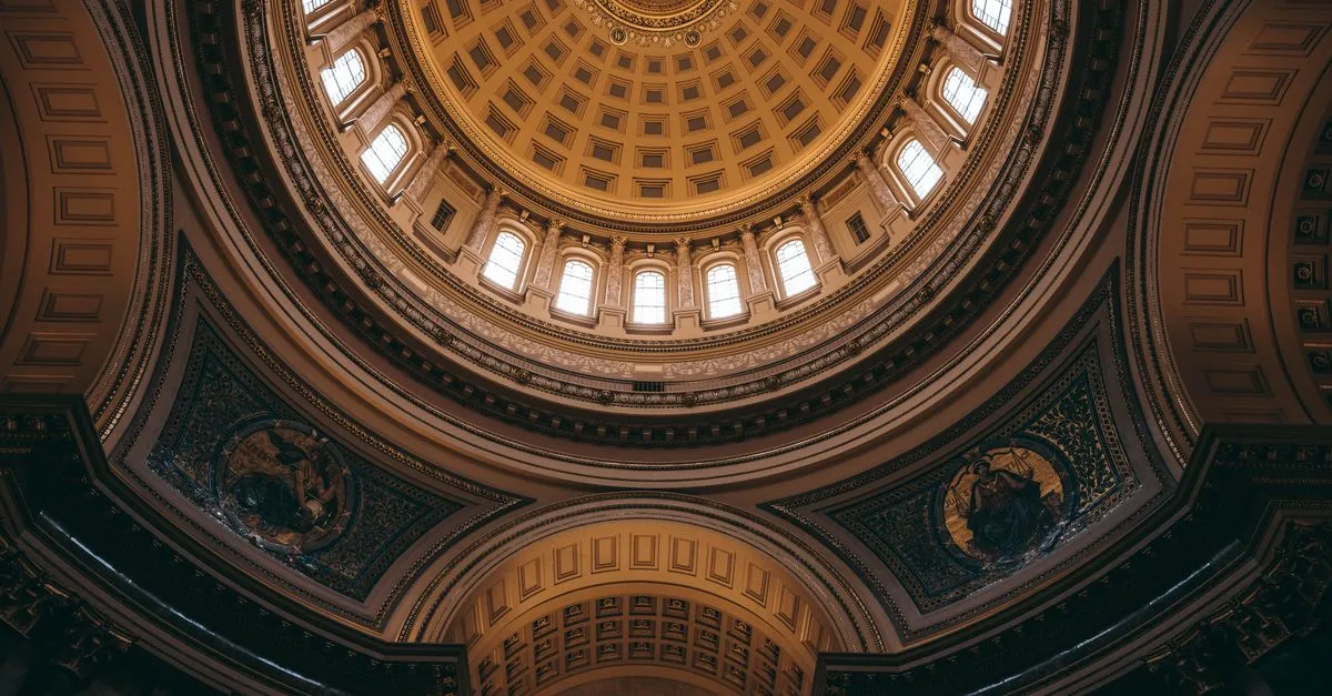 The ornate interior dome of the Wisconsin State Capitol in Madison, viewed looking straight up from the rotunda floor.