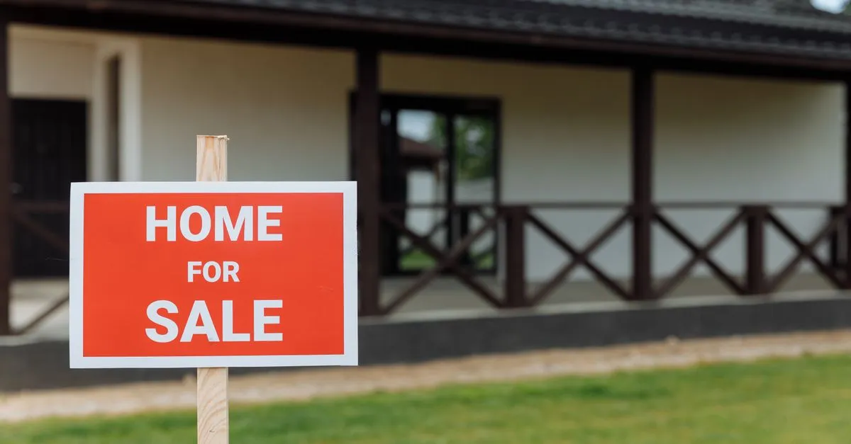 A red home for sale sign outside a house, the kind of listing real estate SEO content helps rank for homes for sale searches.
