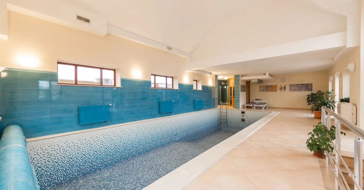 A newly tiled, empty pool being finished before the first fill, the kind of construction project a pool company delivers.