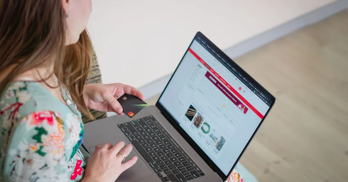 A shopper browsing a marketplace on a laptop with a credit card, the moment an Amazon listing has to win.