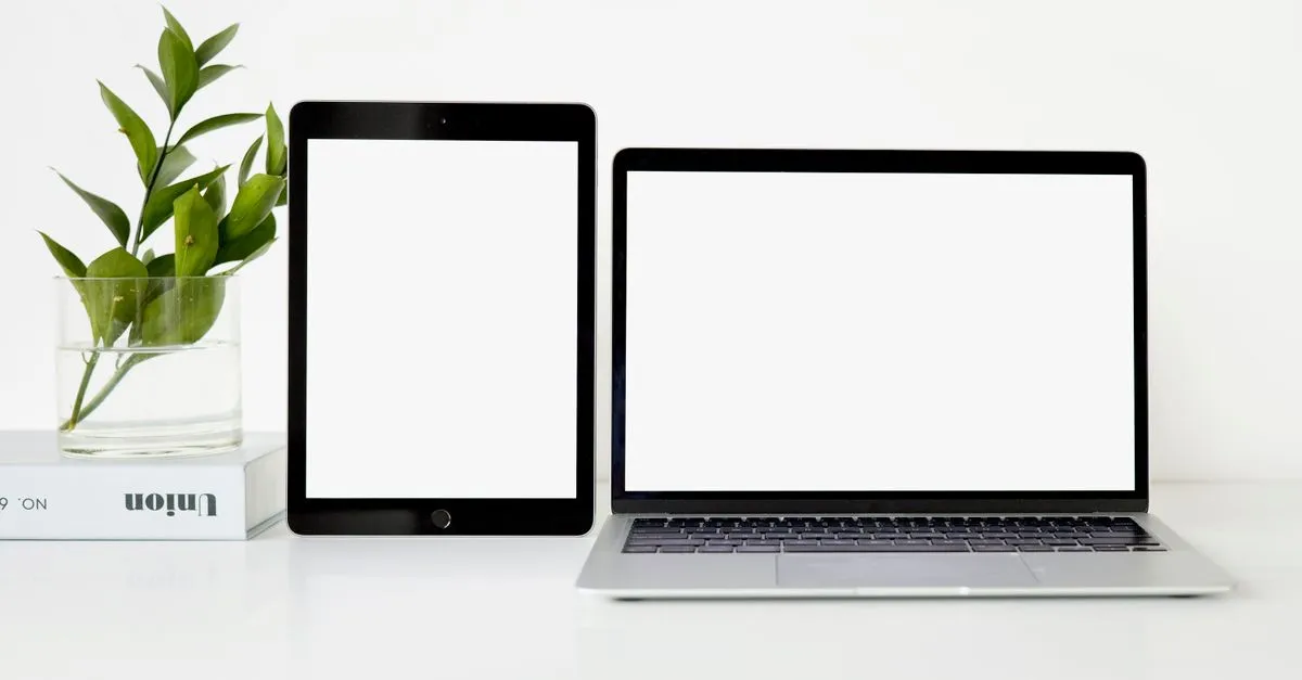 A laptop and tablet side by side showing blank screens, the responsive design work behind a Dallas website.
