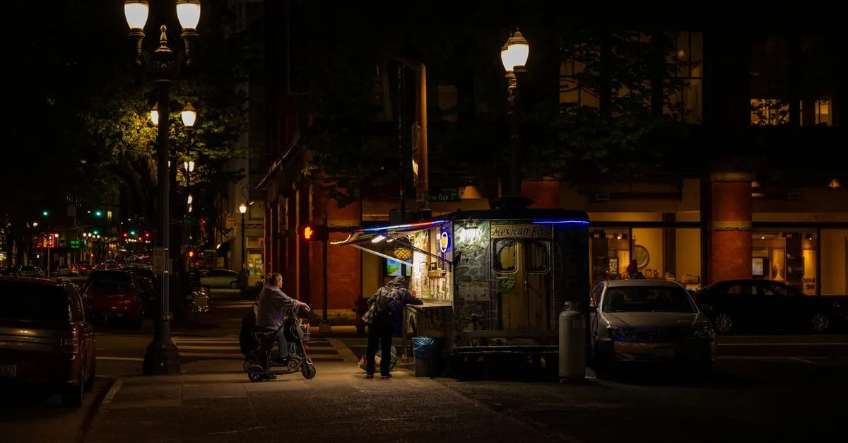 A Portland, Oregon food cart lit up at night on a downtown street corner, the kind of independent business that lives or dies by local search.