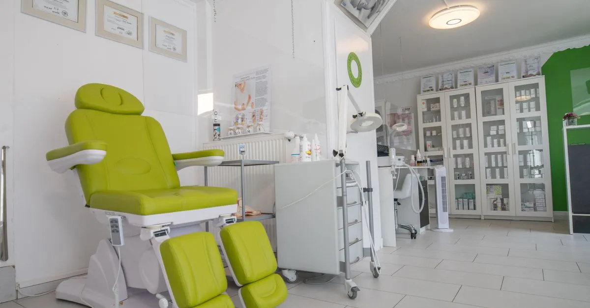 An aesthetic clinic treatment room with a procedure chair and shelves of skincare products, the kind of space a med spa website showcases.