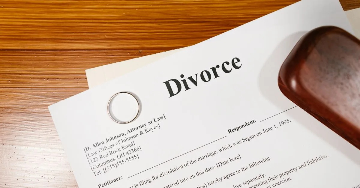 A wedding ring resting on divorce paperwork on a family law attorney's desk.