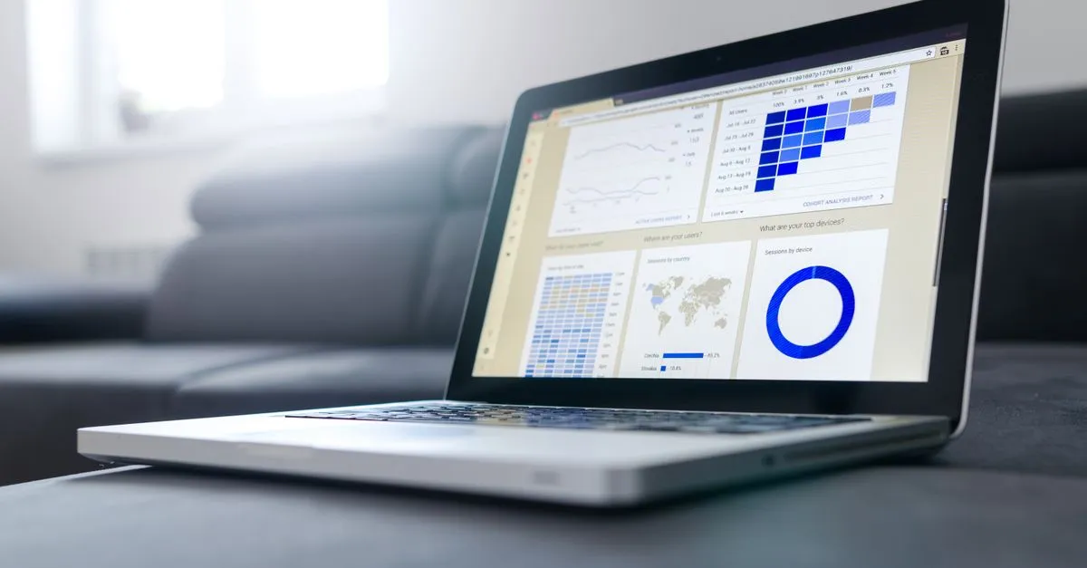 A laptop showing a SaaS analytics dashboard with product usage graphs and charts.