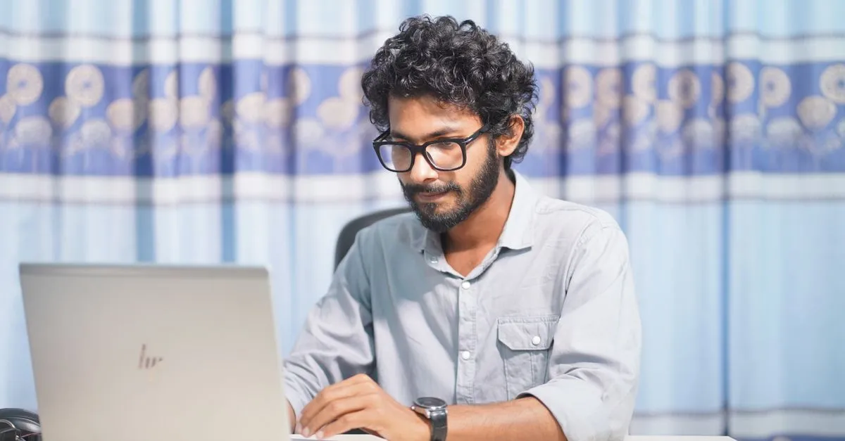 A web professional working on a laptop in a bright room, building a fast Cincinnati website.