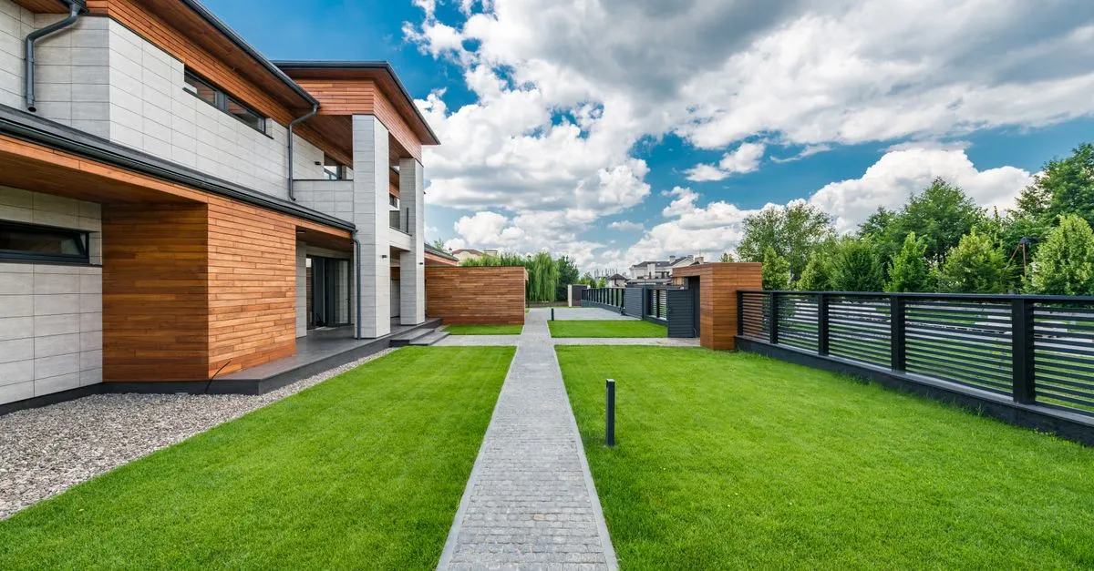 A modern home with a clean fence line wrapping the yard, the kind of completed project that fills a fencing company photo gallery.