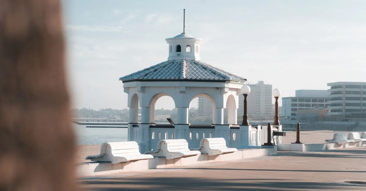 A white waterfront gazebo on the Corpus Christi bayfront overlooking the bay under a clear sky.