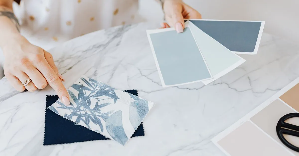 A designer selecting color and material swatches at a desk, the planning work behind a fast Albuquerque website.