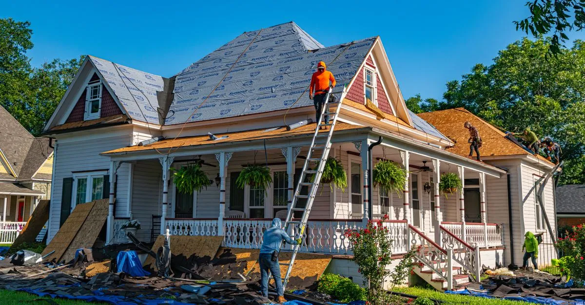 A roofing crew replacing the roof of a house, the kind of before-and-after job a roofing company website puts in its gallery.