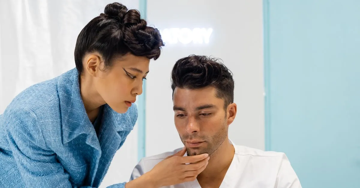 A plastic surgery consultant assessing a patient's facial features during a cosmetic surgery consultation.