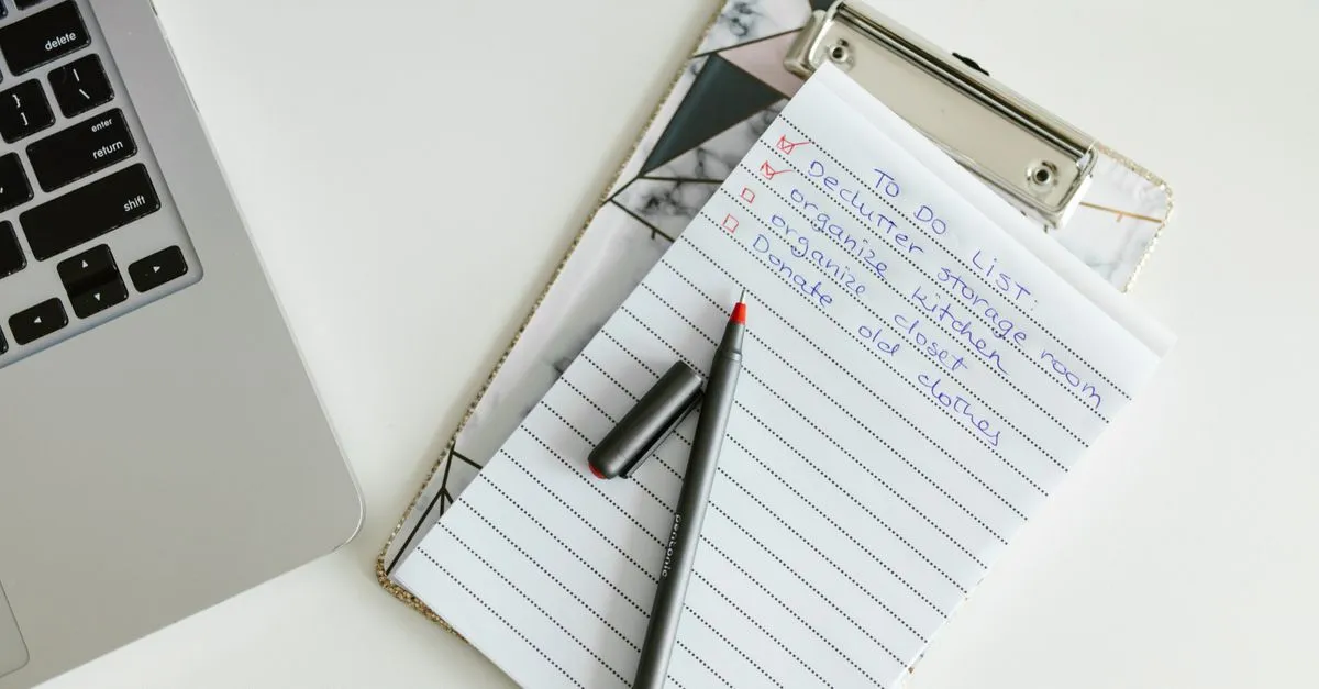 A website audit checklist on a clipboard next to a laptop.
