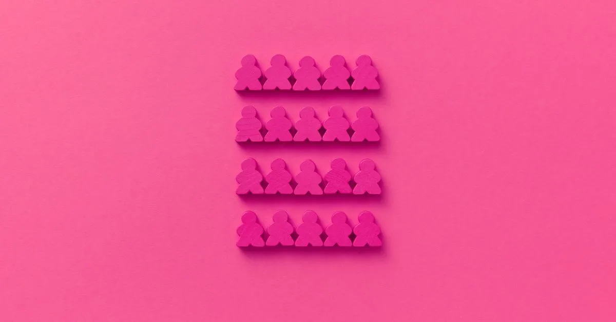 Vibrant pink game pawns arranged in identical neat rows on a matching pink background.