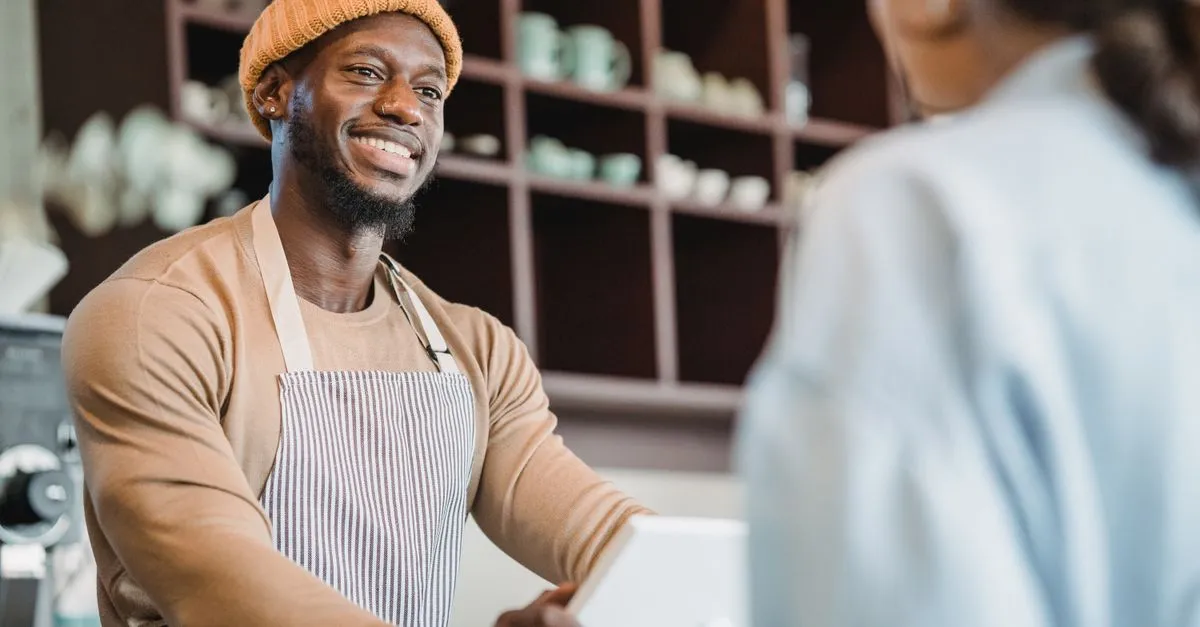 A barista helping a happy customer, the moment right before asking for a review.