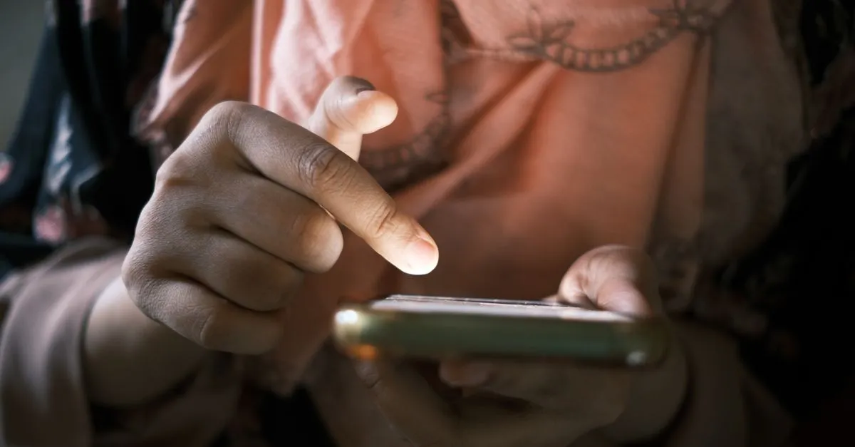 A person tapping a smartphone screen with one finger, the way people flick through a mobile feed.