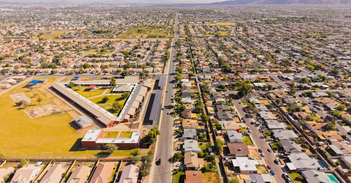 Aerial view of Phoenix, Arizona spreading across the Valley in a grid of homes and streets toward the distant downtown skyline, the sprawling market where the local map pack is won.