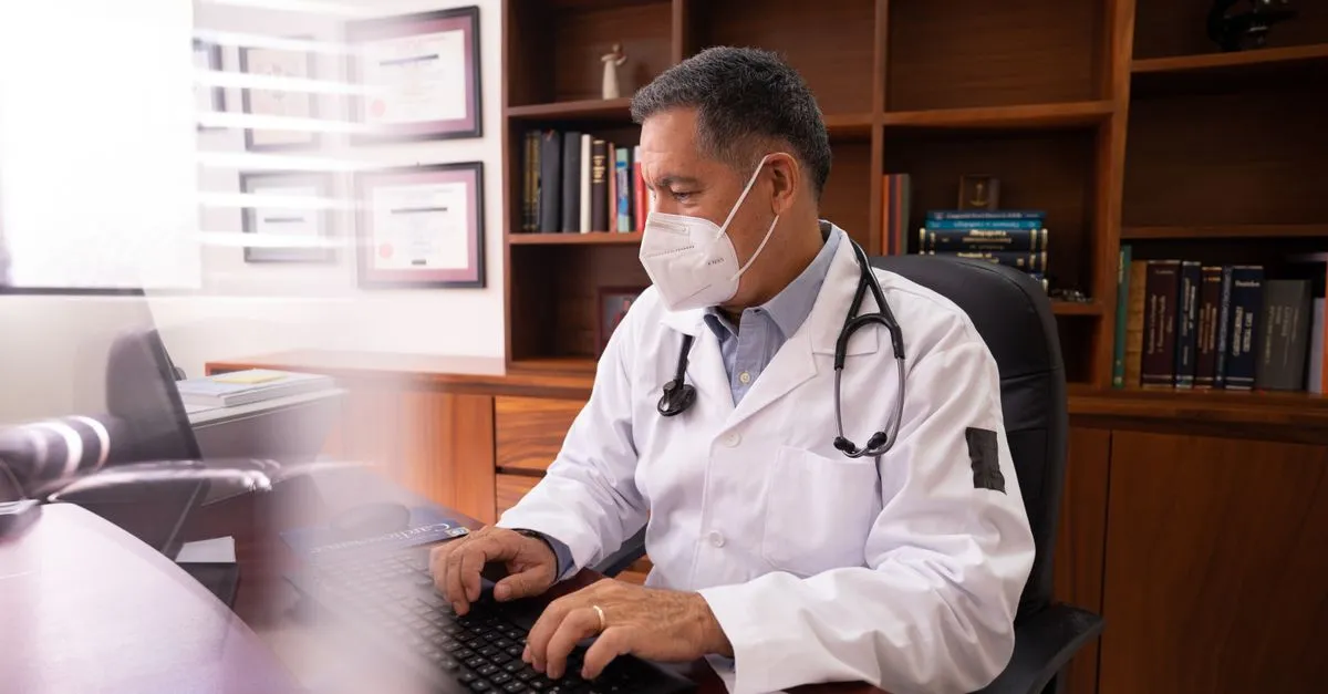 A doctor working at a computer in a clinic office, the kind of practice these medical practice websites are built for.