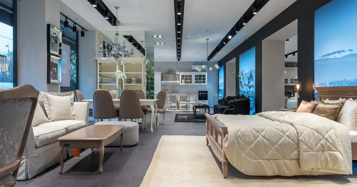Modern furniture showroom displaying a styled bed, soft couch, and dining table, the kind of store SEO for furniture stores helps shoppers find.
