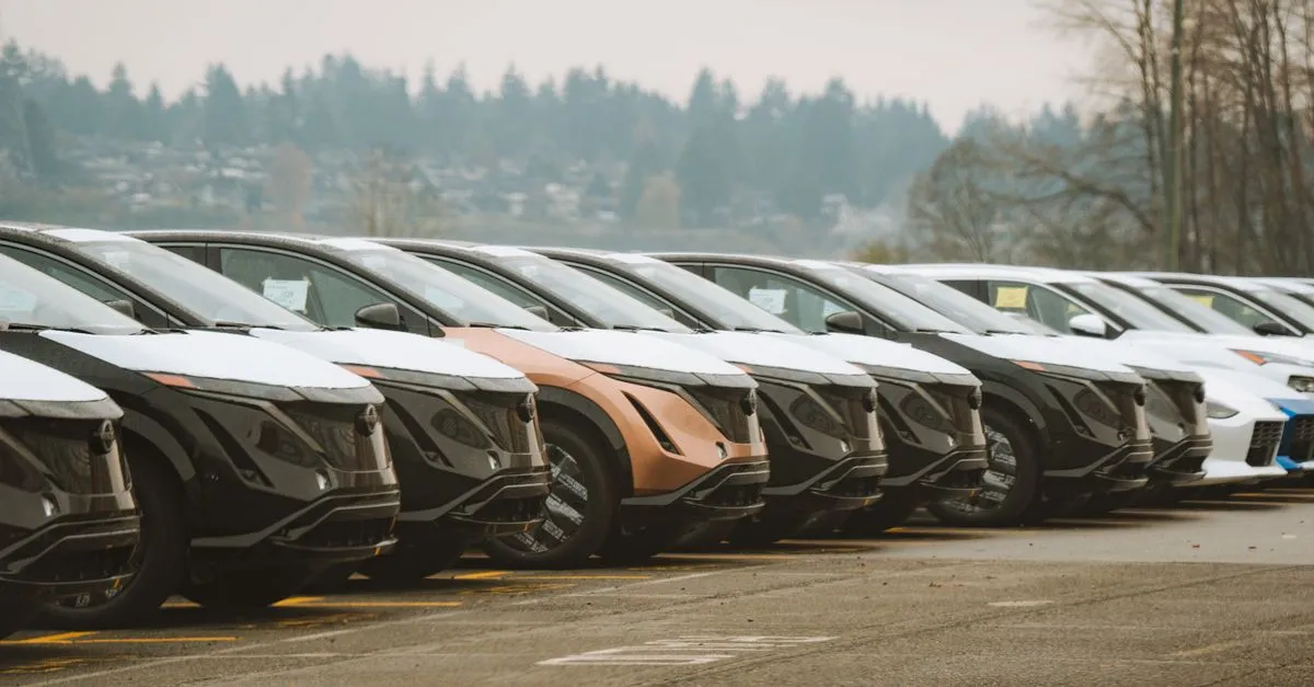 A long row of new and used cars parked on a dealership lot, the kind of inventory local SEO for car dealerships helps nearby shoppers find.