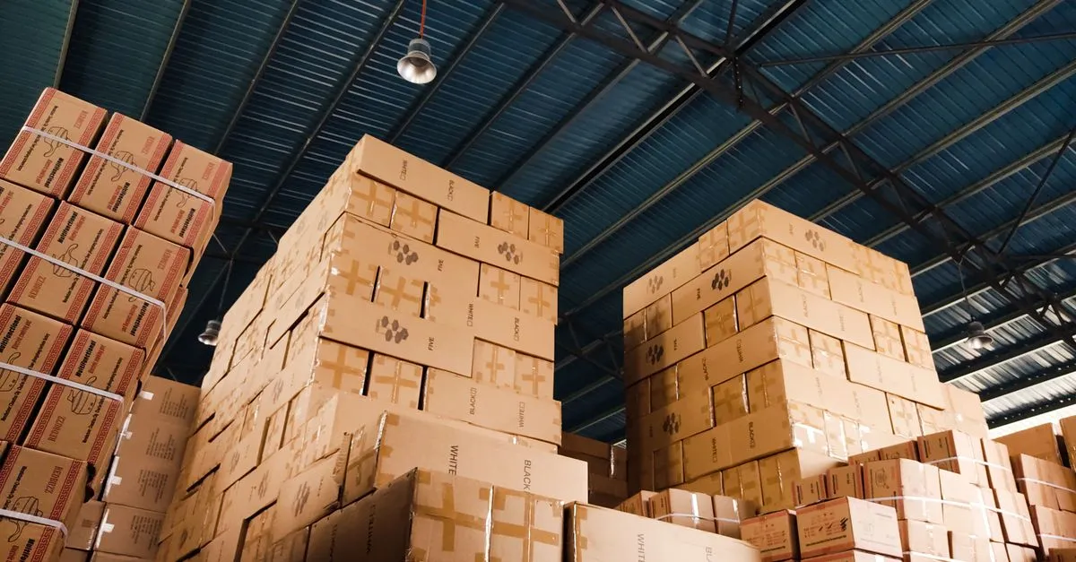 High stacks of cardboard shipping boxes in a warehouse, the kind of inventory an Amazon SEO company helps sellers move.