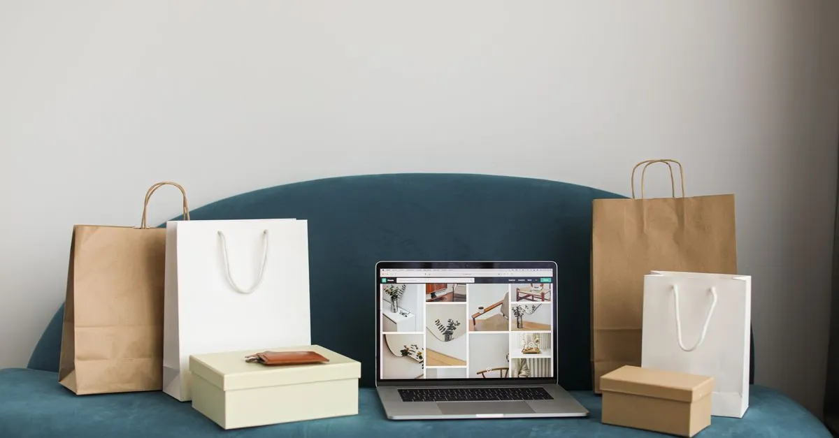 A laptop surrounded by shopping bags and boxes, representing an online store that ecommerce SEO helps grow.