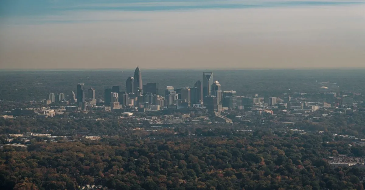 The Charlotte skyline with the crown-topped Bank of America Corporate Center rising over Uptown and fall foliage, the banking metro where the map pack is won.